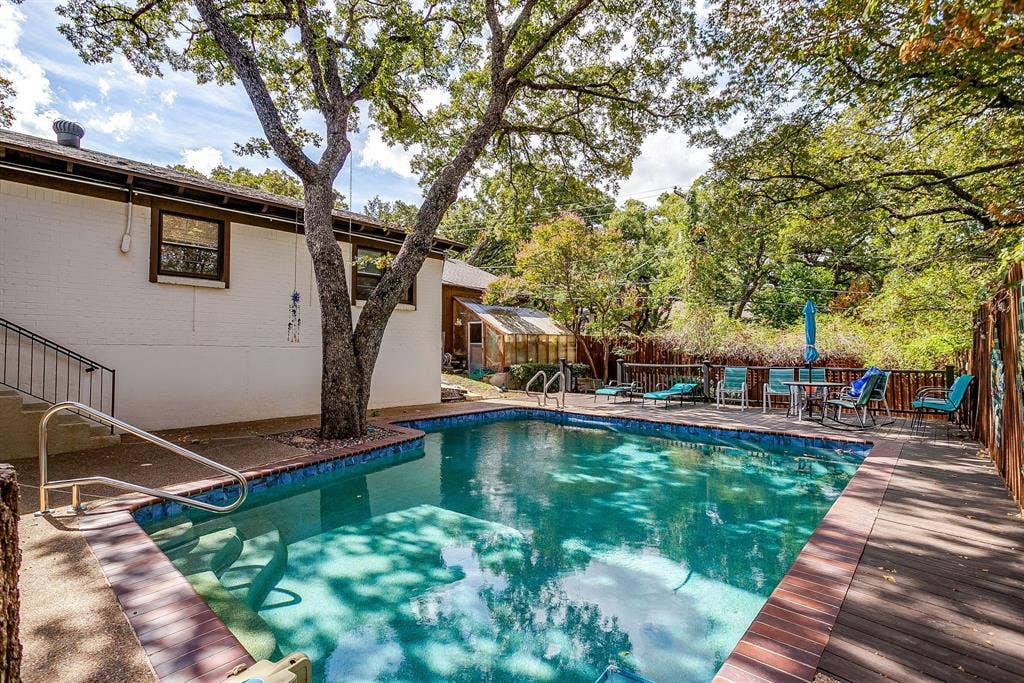 Rectangular swimming pool with integrated steps, surrounded by brick coping and a concrete deck