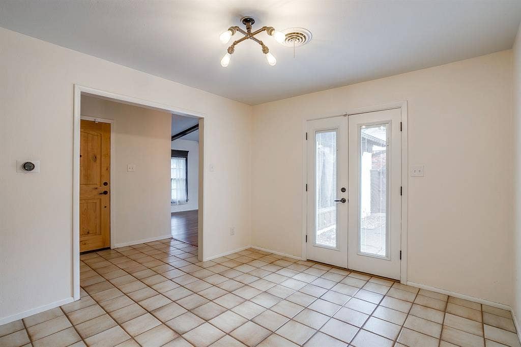 Ceramic tile flooring, French doors with glass panels, recessed archway, wood panel door, and industrial-style ceiling light fixture