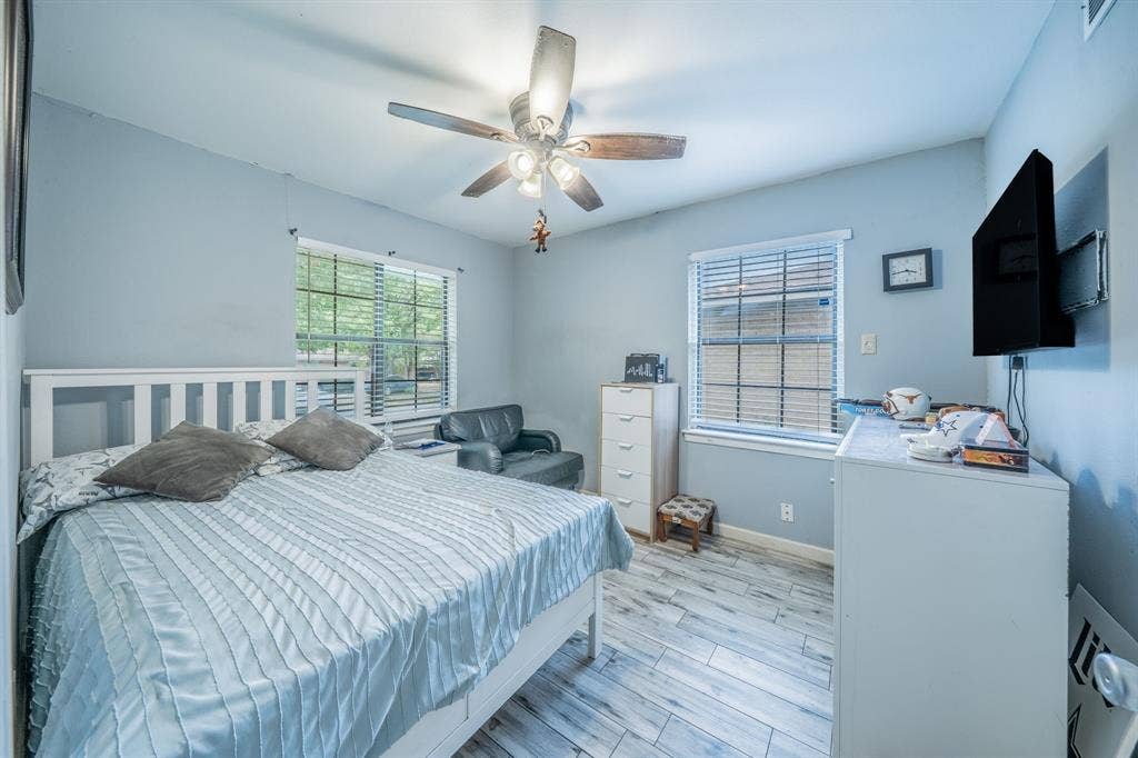 1938 Balla Way, Grand Prairie, TX 75051 Wood-finish flooring with a ceiling fan light fixture and multiple windows with blinds