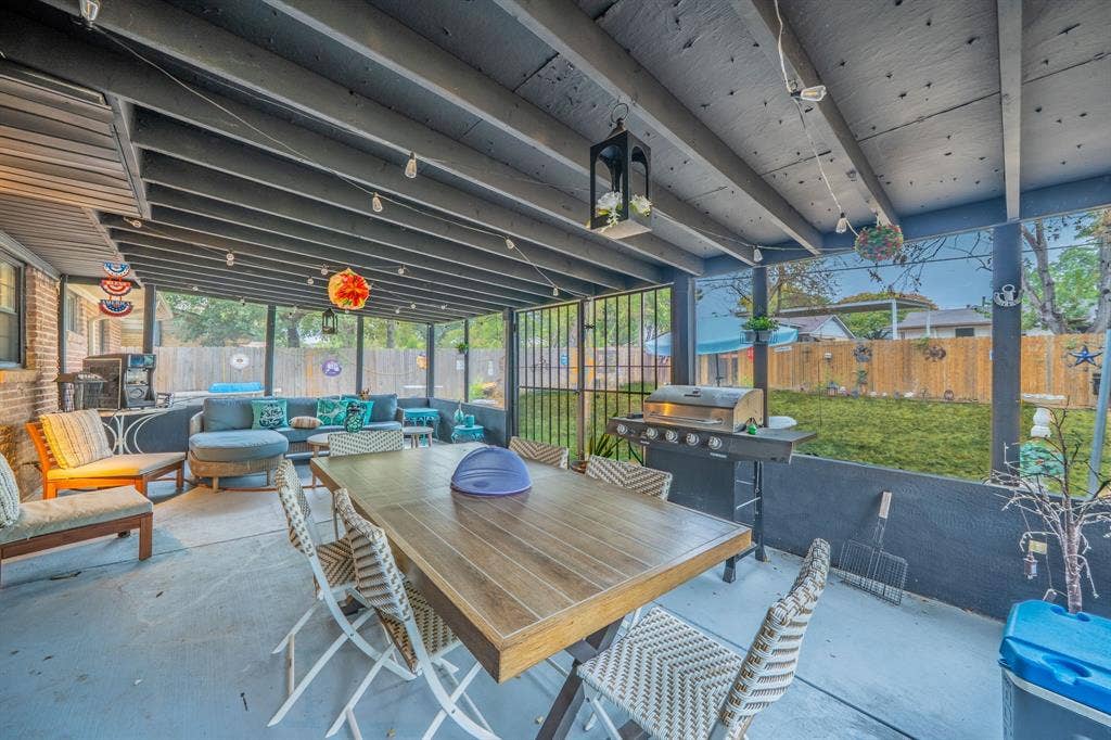 1938 Balla Way, Grand Prairie, TX 75051 Screened patio featuring a solid roof, concrete flooring, and an exposed brick exterior wall