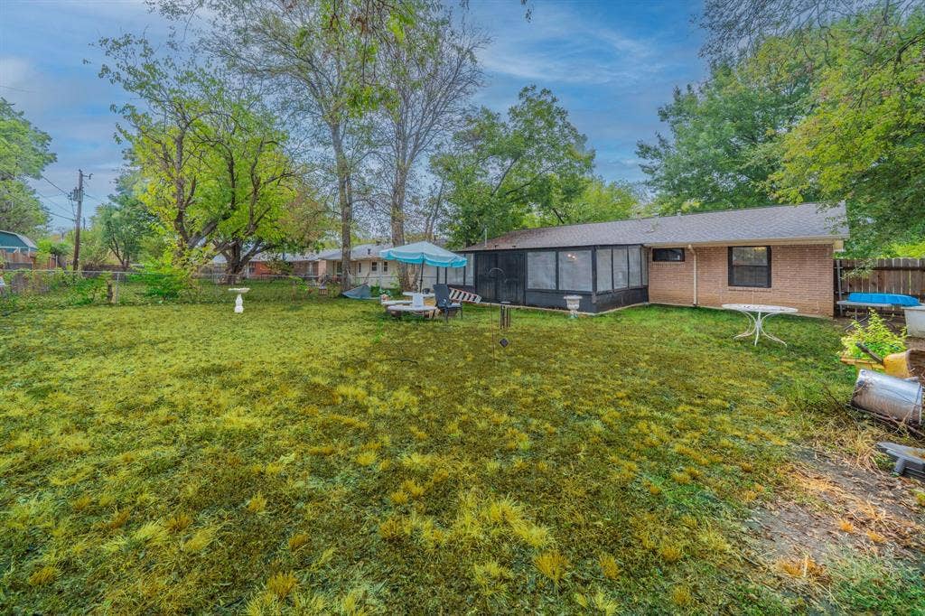1938 Balla Way, Grand Prairie, TX 75051 Expansive level lot with mature shade trees and lush lawn, anchored by a brick residence and modern black-clad addition