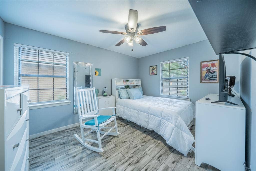 1938 Balla Way, Grand Prairie, TX 75051 Wood-finish flooring, two windows with blinds, and a ceiling fan with light fixture