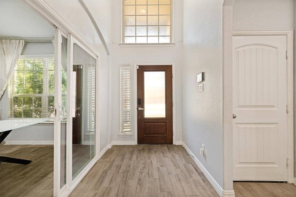 818 Black Hawk Drive, Princeton, TX 75407 Two-story entryway featuring wood-finish flooring, a transom window, and a paneled entry door with frosted glass