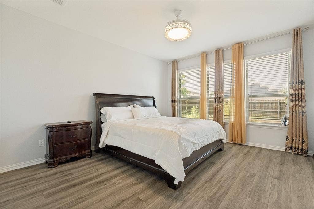 818 Black Hawk Drive, Princeton, TX 75407 Wood-finish flooring, multiple windows with blinds, ceiling-mounted light fixture, and white wall finishes