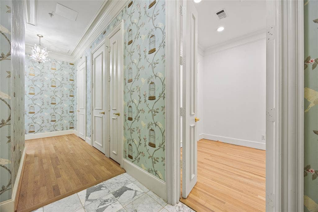 3535 Gillespie Street, #507, Dallas, TX 75219 Hallway featuring decorative wallpaper, wood-finish flooring, and white paneled doors