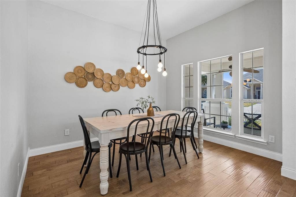 9828 Meadow Rue Drive, McKinney, TX 75072 A warm and welcoming dining space with large windows and plenty of room to gather.