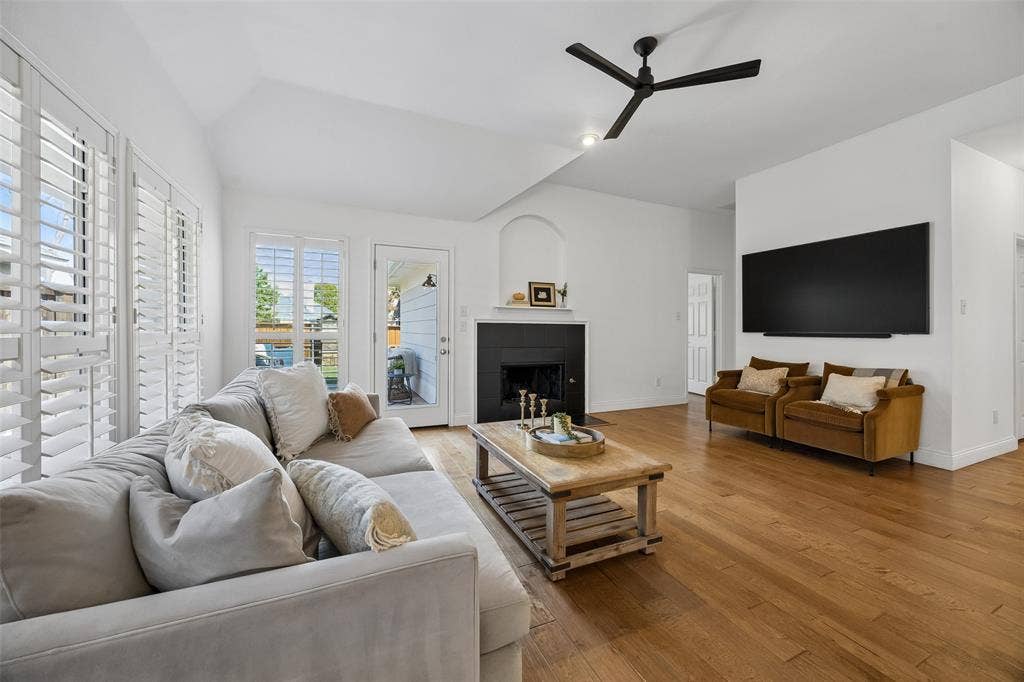 9828 Meadow Rue Drive, McKinney, TX 75072 Bright and comfortable family room with warm wood flooring and a cozy gas start fireplace.