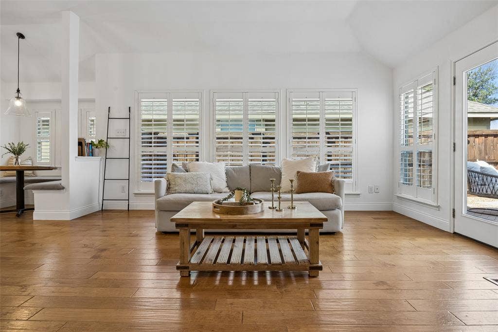 9828 Meadow Rue Drive, McKinney, TX 75072 Plantation shutters bring in beautiful natural light while the fireplace creates a welcoming focal point.