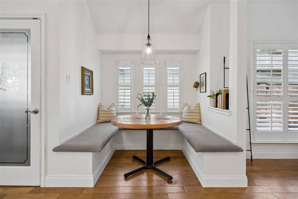 9828 Meadow Rue Drive, McKinney, TX 75072 Cozy breakfast nook with built in seating, plantation shutters and a modern pendant light.