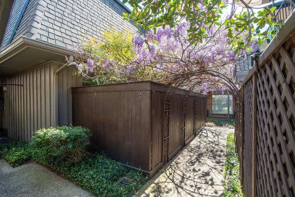 4112 Bowser Avenue, #210, Dallas, TX 75219 Private fenced courtyard featuring a decorative metal archway and rich landscaping