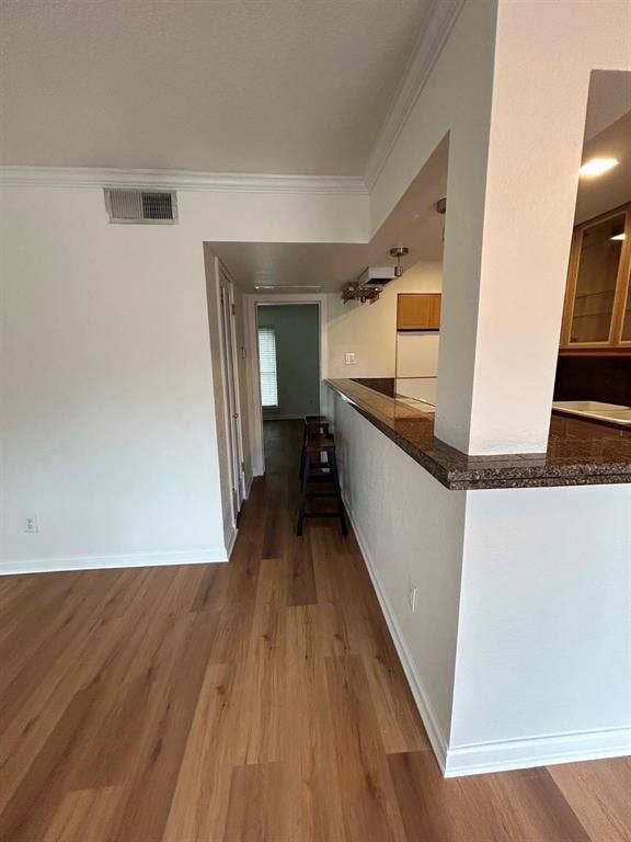 4112 Bowser Avenue, #210, Dallas, TX 75219 Wood-finish flooring throughout, crown molding, and a kitchen pass-through with a stone-finish countertop