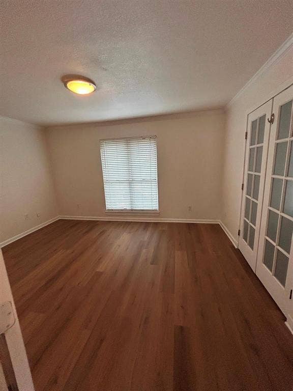 4112 Bowser Avenue, #210, Dallas, TX 75219 Wood-finish flooring, white crown molding, recessed window with blinds, and double French doors with frosted glass panels