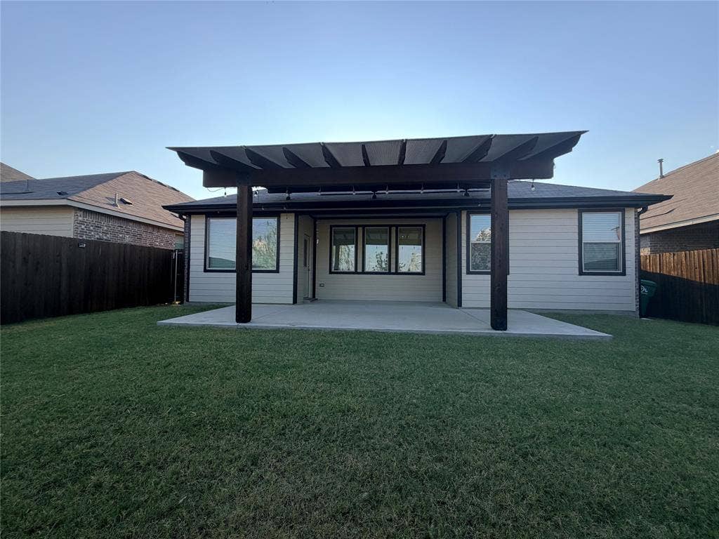 3308 Chasemoor Drive, Denton, TX 76207 Expansive backyard featuring a concrete patio, a dark wood pergola, and a dark wood privacy fence