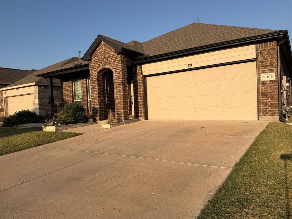3308 Chasemoor Drive, Denton, TX 76207 Brick exterior with a prominent arched entrance and a two-car garage