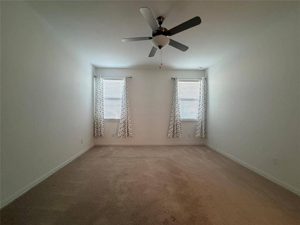 3308 Chasemoor Drive, Denton, TX 76207 Neutral-toned carpeting, two windows with blinds, and a ceiling fan with integrated lighting