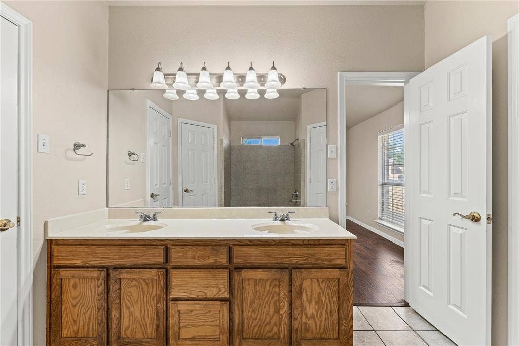 624 Willow Creek Drive, Hewitt, TX 76643 Double vanity with light wood-finish cabinetry, white countertop, and dual undermount sinks