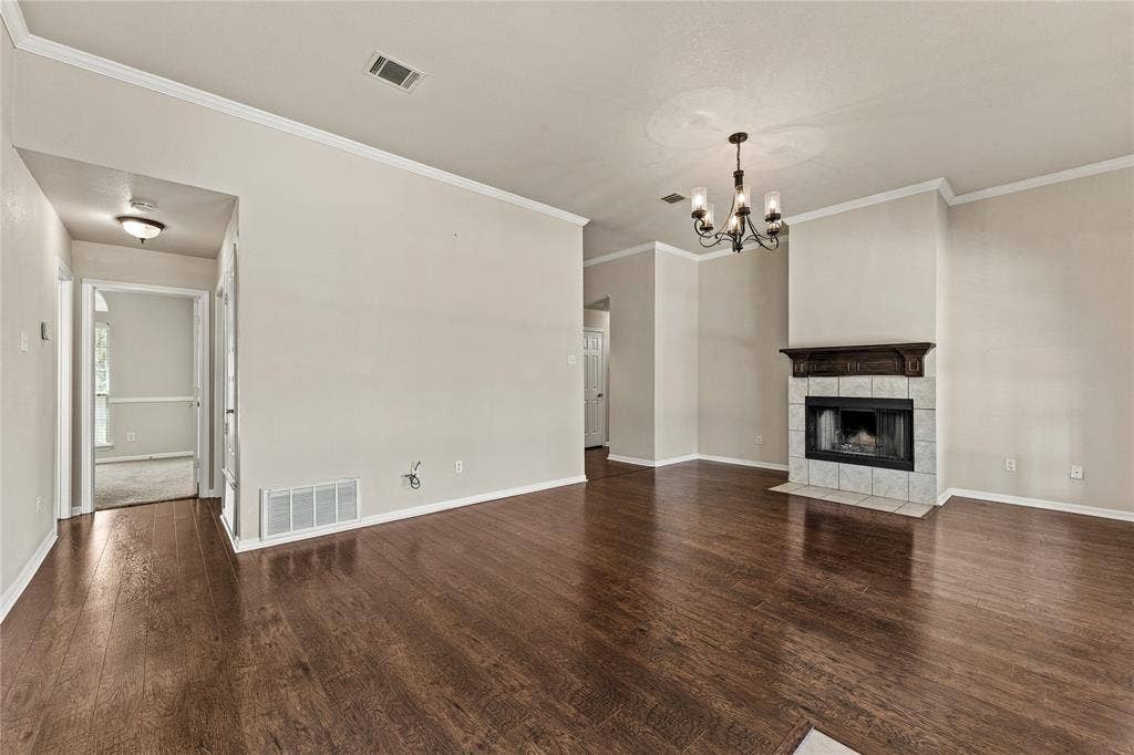624 Willow Creek Drive, Hewitt, TX 76643 Hardwood-finish flooring, recessed fireplace with tile surround, decorative mantel, chandelier lighting, and crown molding