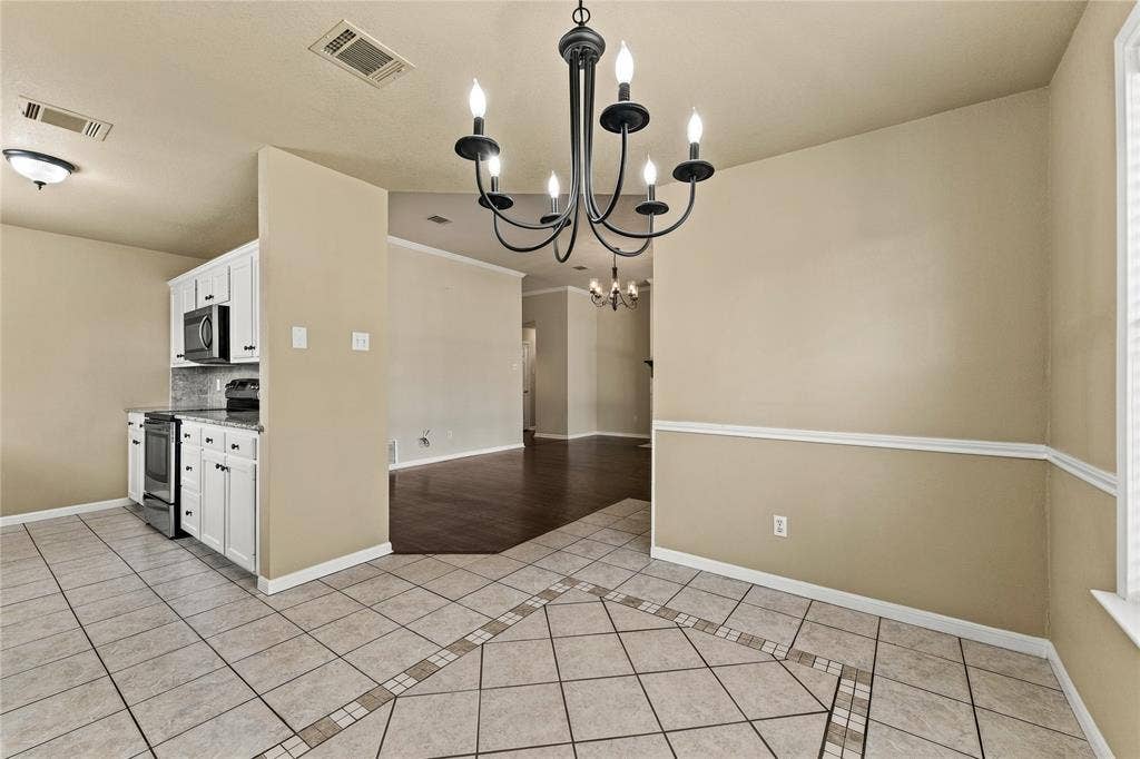 624 Willow Creek Drive, Hewitt, TX 76643 Tile flooring with an inlaid pattern, a chandelier, white cabinetry, a stainless steel oven/range, and a built-in microwave