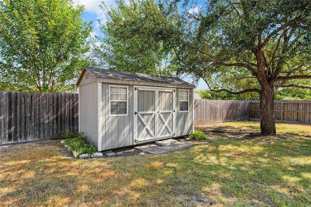 624 Willow Creek Drive, Hewitt, TX 76643 Detached storage shed with double barn doors and two windows, set on a stone paver foundation