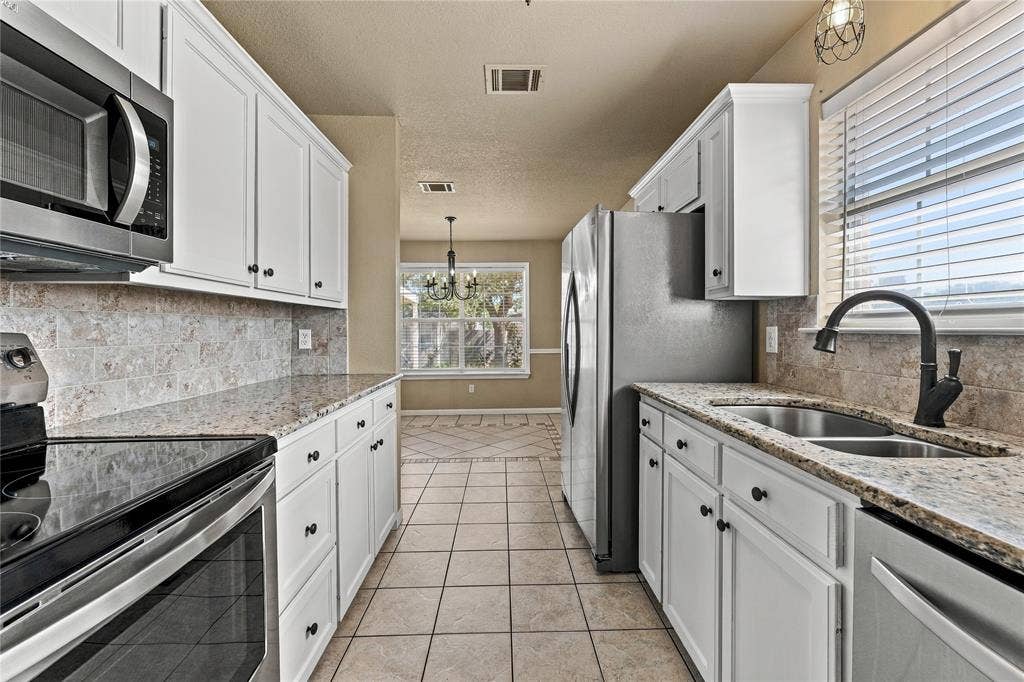 624 Willow Creek Drive, Hewitt, TX 76643 Kitchen featuring white cabinetry, granite countertops, stainless steel appliances, a tile backsplash, and tile flooring