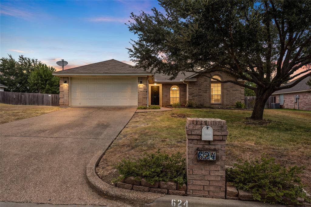 624 Willow Creek Drive, Hewitt, TX 76643 Brick exterior with arched window accents, attached two-car garage, and a concrete driveway