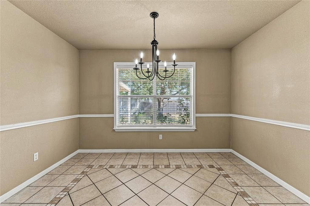 624 Willow Creek Drive, Hewitt, TX 76643 Tile flooring with an inlaid pattern, neutral wall tones, decorative chair rail molding, and a central window with blinds