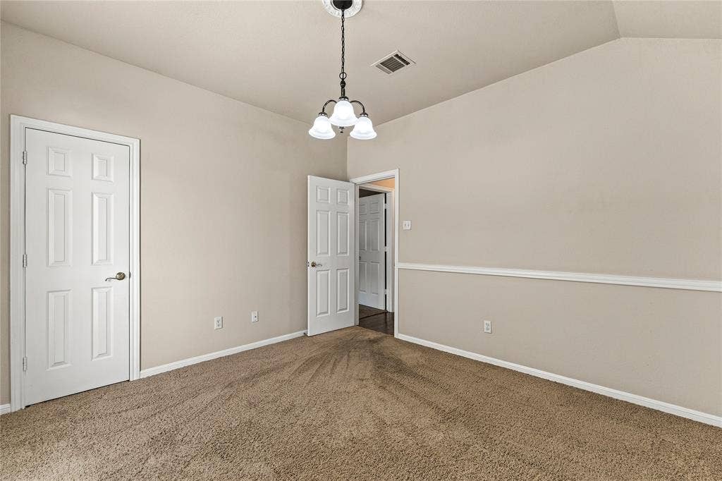 624 Willow Creek Drive, Hewitt, TX 76643 Carpeted room with vaulted ceiling and a three-light chandelier