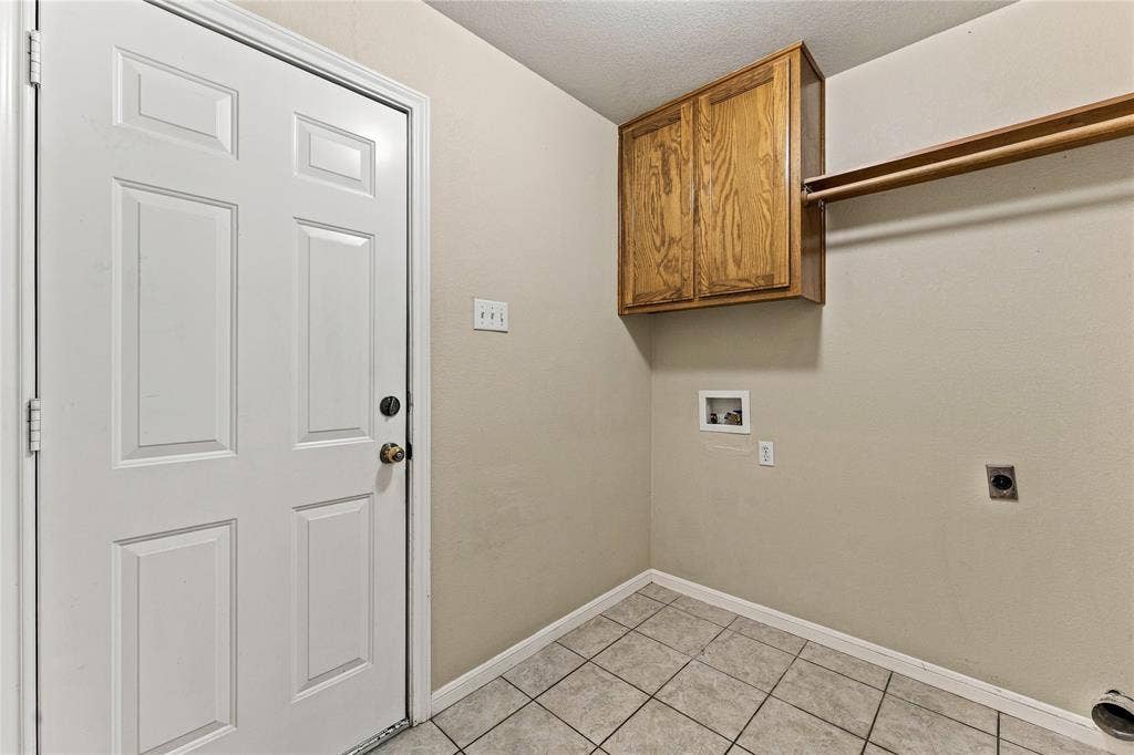 624 Willow Creek Drive, Hewitt, TX 76643 Tiled flooring, overhead wood cabinetry, and a wall-mounted clothes rod