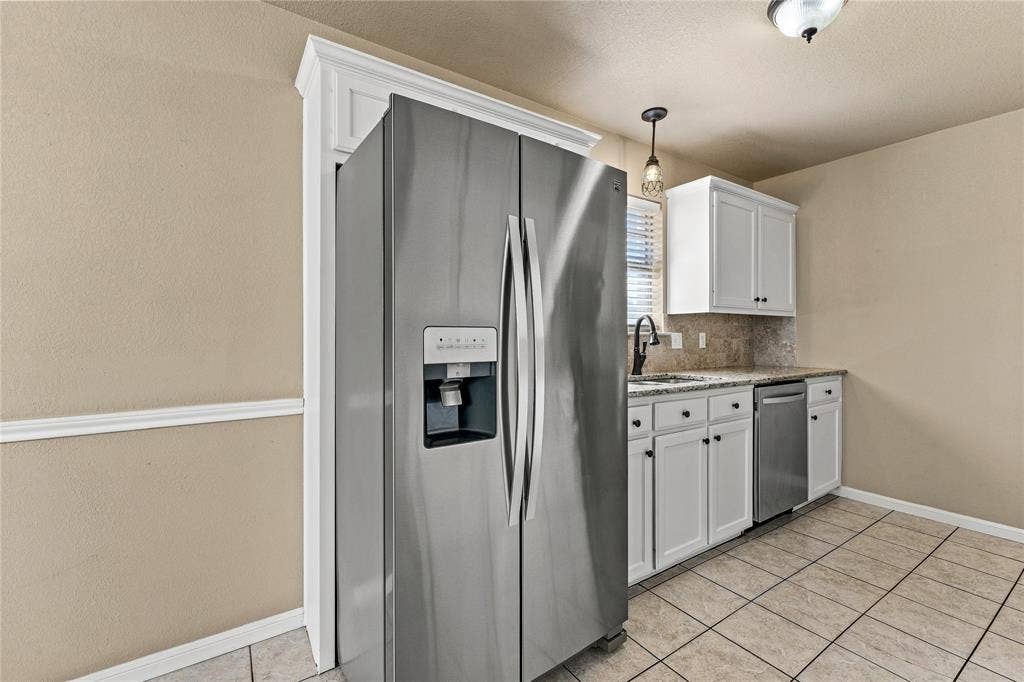 624 Willow Creek Drive, Hewitt, TX 76643 Built-in stainless steel refrigerator, white cabinetry, polished countertop, stainless steel dishwasher, and tile flooring