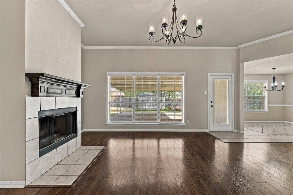 624 Willow Creek Drive, Hewitt, TX 76643 Wood-finish flooring, tiled fireplace with a dark wood mantel, large window with blinds, and a glass-paneled door