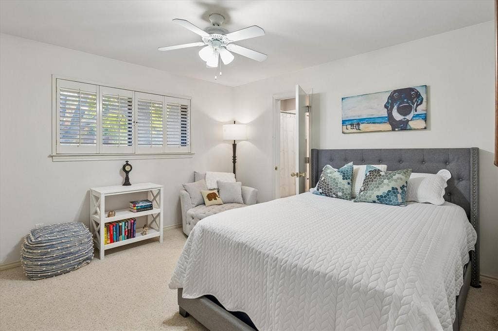 7603 Queens Ferry Lane, Dallas, TX 75248 Neutral tone wall finishes, white plantation shutters, and a ceiling fan with integrated lighting