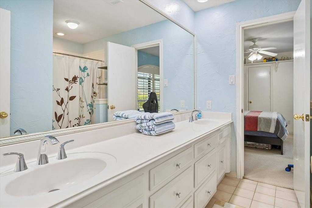 7603 Queens Ferry Lane, Dallas, TX 75248 Dual under-mount sinks with chrome faucets, expansive countertop, and built-in vanity cabinetry