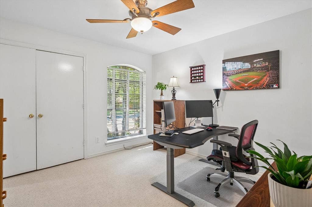 7603 Queens Ferry Lane, Dallas, TX 75248 Carpeted room featuring a ceiling fan with integrated lighting, an arched window, and bi-fold closet doors