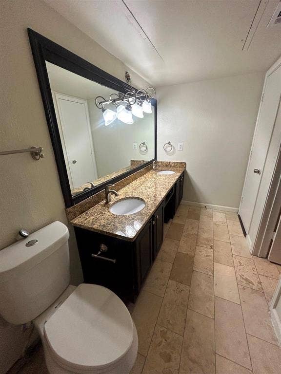 7525 Holly Hill Drive, #45, Dallas, TX 75231 Dual vanity with granite-style countertop, undermount sinks, dark wood-finish cabinetry, and tiled flooring
