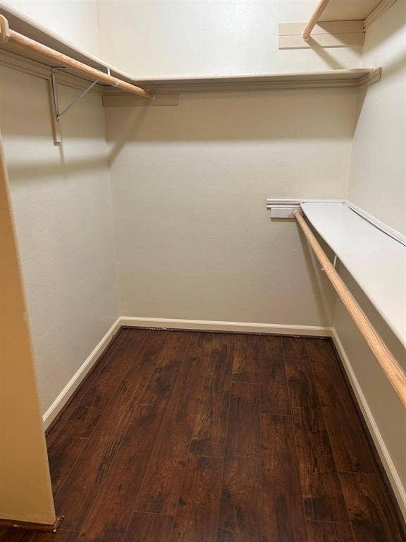 7525 Holly Hill Drive, #45, Dallas, TX 75231 Closet featuring wood-finish flooring, built-in shelving, and hanging rods