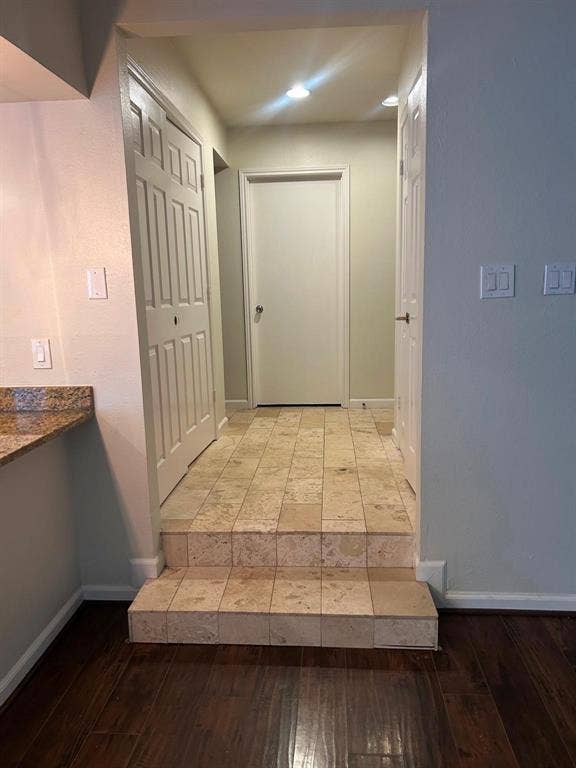 7525 Holly Hill Drive, #45, Dallas, TX 75231 Wood-finish flooring with a multi-level transition to a tiled landing