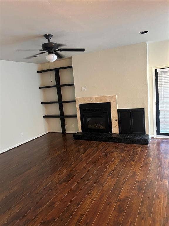 7525 Holly Hill Drive, #45, Dallas, TX 75231 Wood-finish flooring, ceiling fan, built-in shelving, fireplace with stone surround, recessed lighting