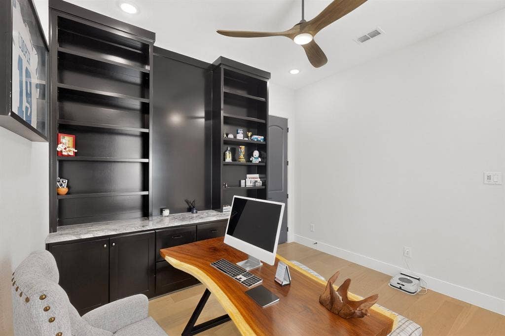 2519 Tamaron Cove, Cedar Hill, TX 75104 Built-in black cabinetry, integrated shelving, stone-finish countertop, wood-finish flooring, and a ceiling fan with integrated lighting
