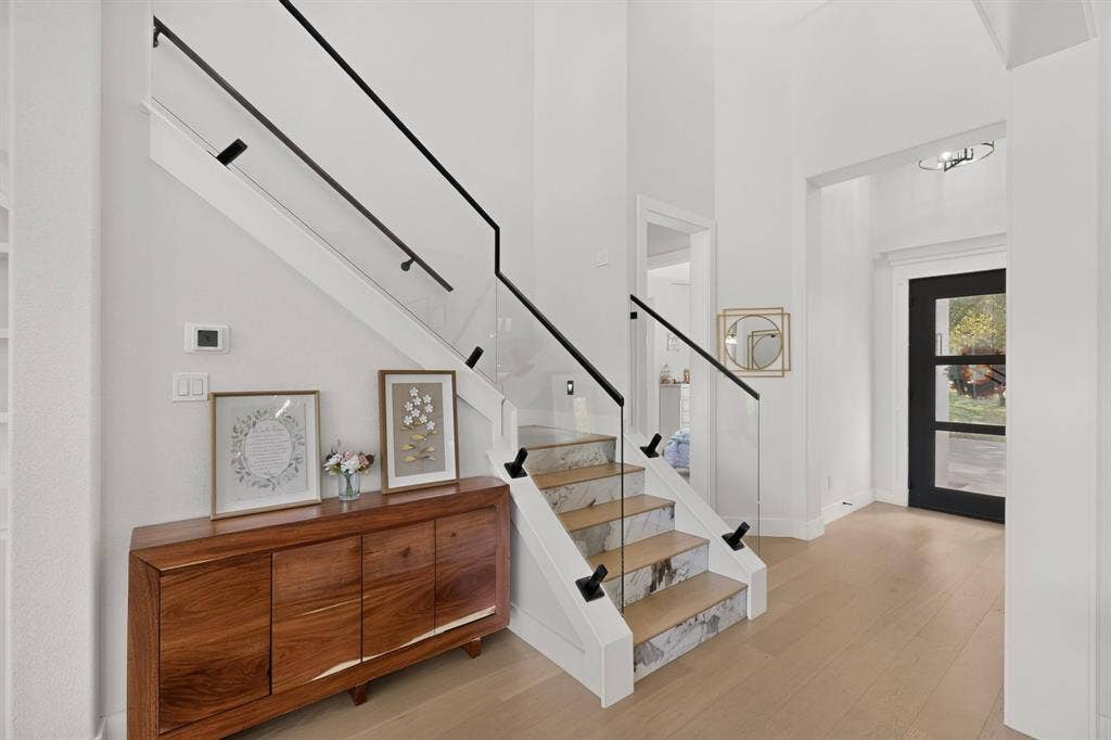 2519 Tamaron Cove, Cedar Hill, TX 75104 Contemporary staircase with glass panel railing and black handrail, light wood-finish flooring, and white walls