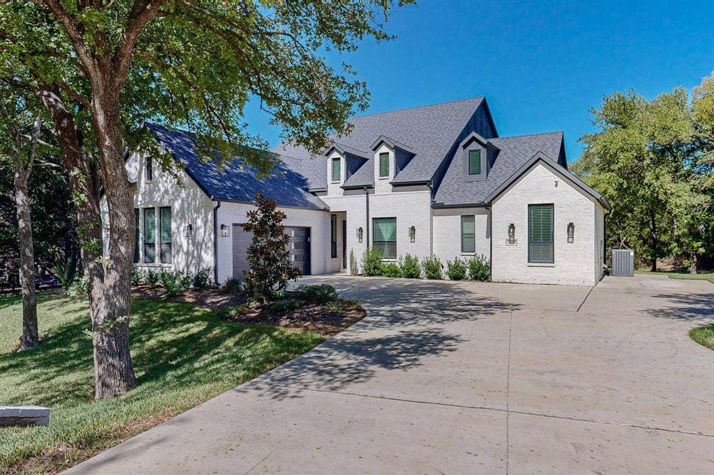 2519 Tamaron Cove, Cedar Hill, TX 75104 White brick exterior with dark trim windows, multi-pitch roofline, dormer windows, and a concrete driveway