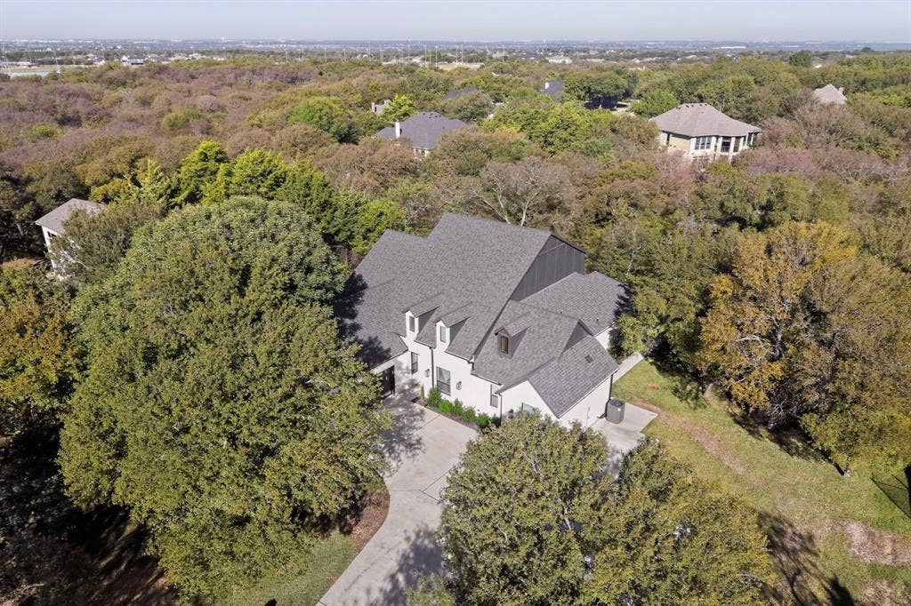2519 Tamaron Cove, Cedar Hill, TX 75104 Multi-story residence featuring a gray shingle roof and dormer windows, surrounded by mature trees