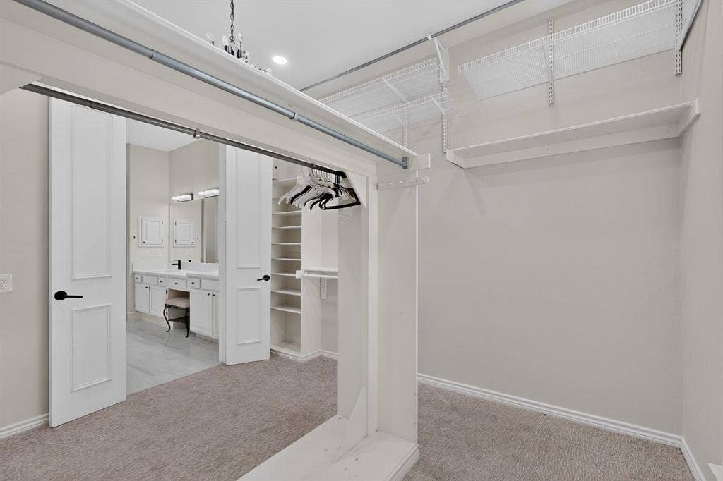 4237 McAlice Drive, Plano, TX 75093 Carpeted walk-in closet with built-in shelving, wire shelving, and hanging rods