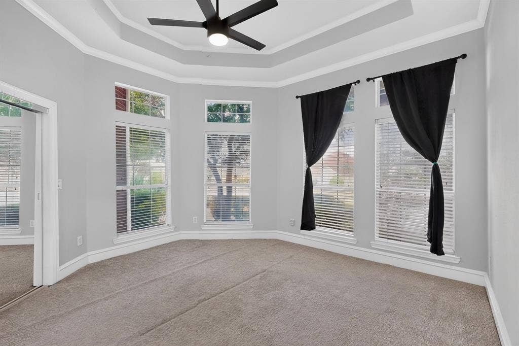 4237 McAlice Drive, Plano, TX 75093 Tray ceiling with crown molding, ceiling fan, multiple windows with blinds, and neutral carpet