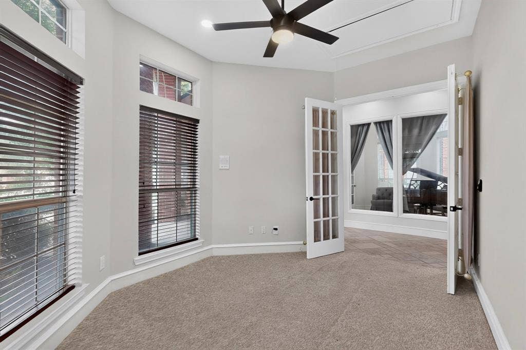 4237 McAlice Drive, Plano, TX 75093 Carpeted room featuring a ceiling fan with integrated lighting, multiple windows with blinds, crown molding, and French doors