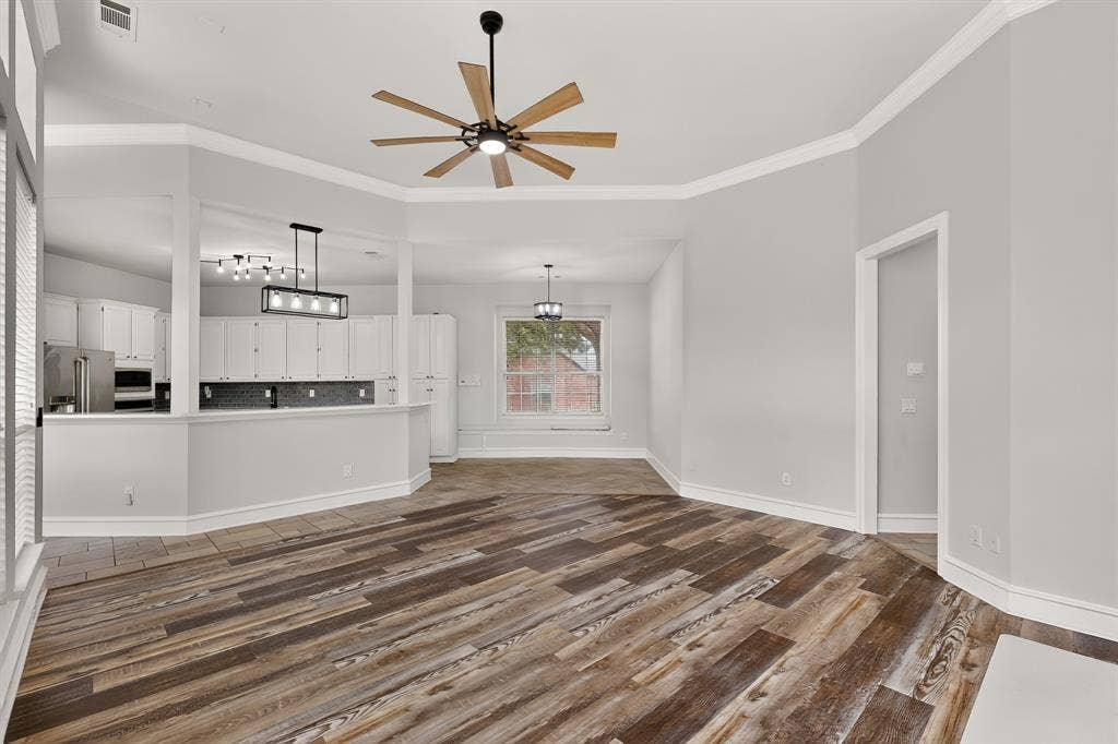 4237 McAlice Drive, Plano, TX 75093 Wood-finish flooring throughout, complemented by a kitchen featuring white cabinetry and stainless steel appliances