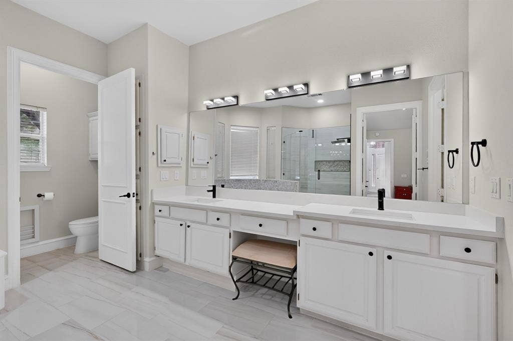 4237 McAlice Drive, Plano, TX 75093 Dual vanities with white cabinetry and integrated sinks