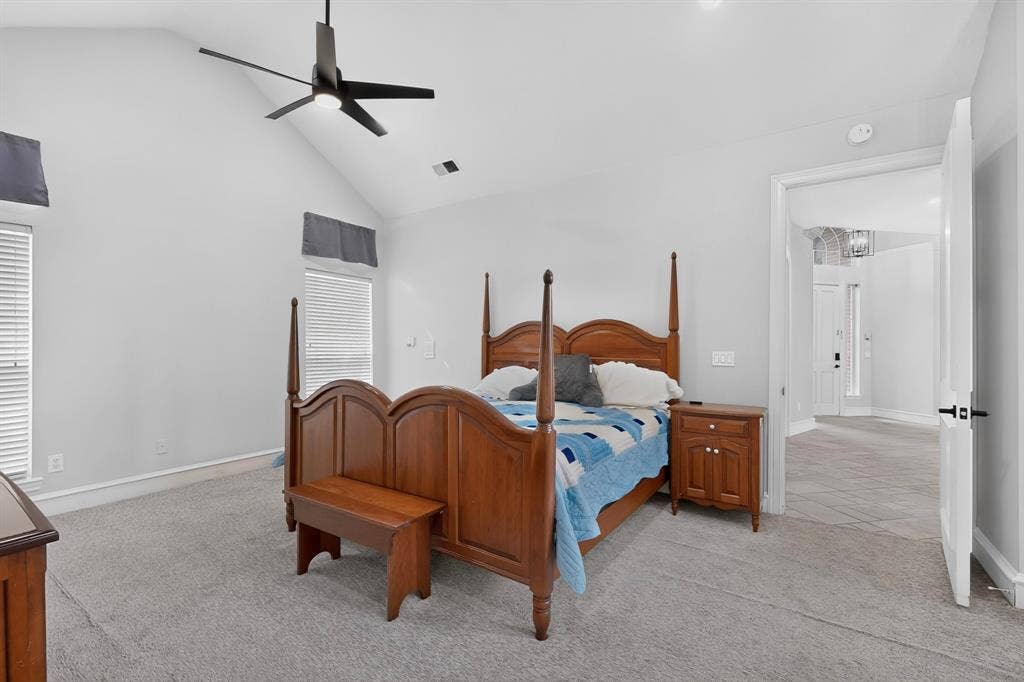 4237 McAlice Drive, Plano, TX 75093 Vaulted ceiling with an attached ceiling fan, large windows with blinds, light gray wall paint, and gray carpet flooring