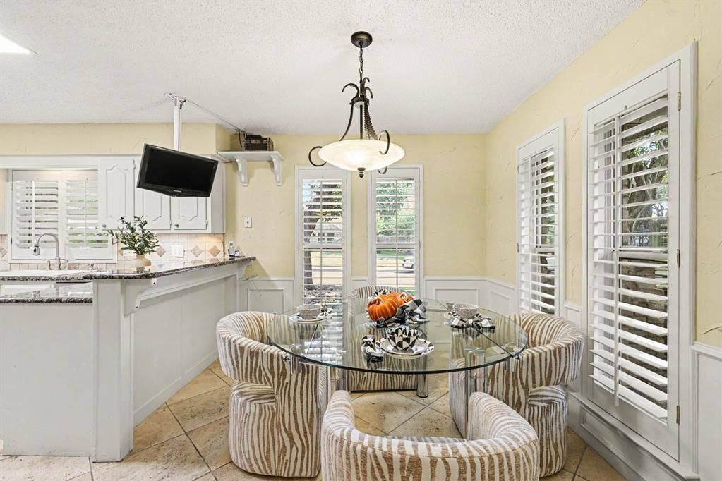 6503 Barfield Drive, Dallas, TX 75252 Plantation shutters, tile flooring, built-in shelving, wainscoting, and a ceiling-mounted light fixture