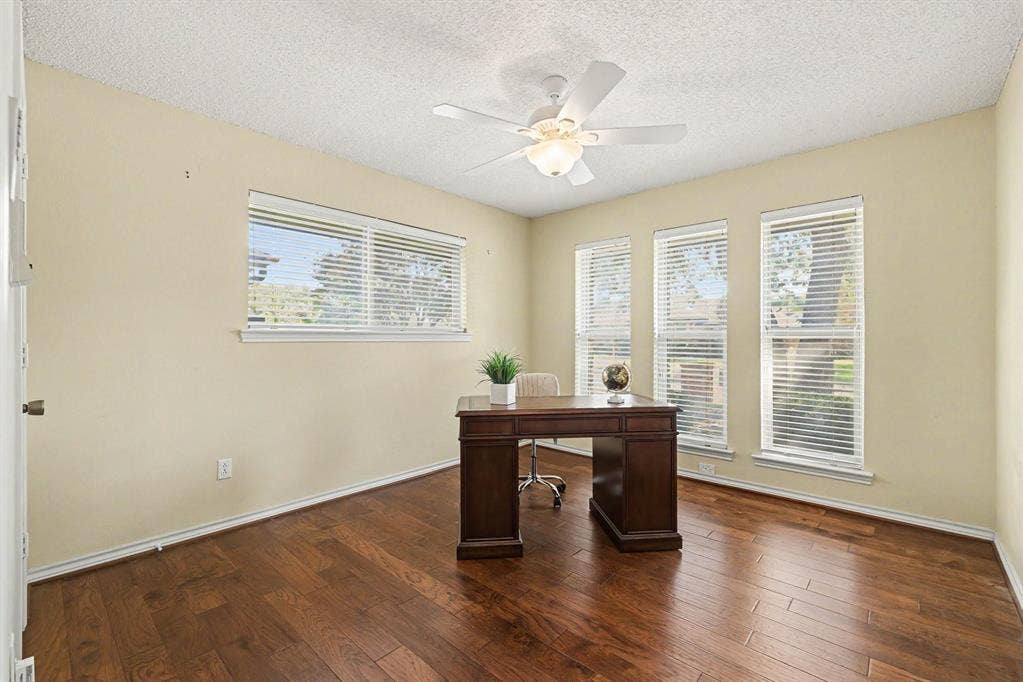 6503 Barfield Drive, Dallas, TX 75252 Hardwood flooring, multiple windows with blinds, ceiling fan with integrated lighting, textured ceiling, and light-colored wall paint