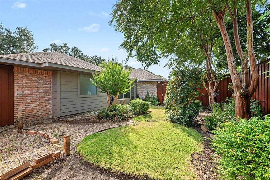 6503 Barfield Drive, Dallas, TX 75252 Brick and siding exterior, sloped roofline, mature trees, and privacy fencing